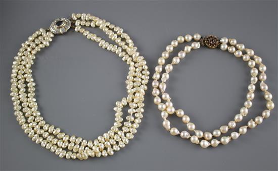 A double strand cultured baroque pearl necklace with yellow metal and garnet ? cluster clasp and one other simulated pearl necklace.